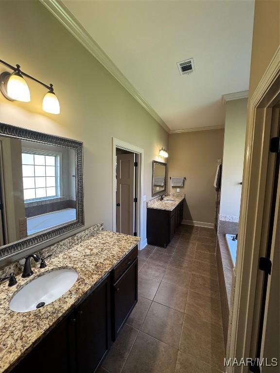3701 Weston Pl, Montgomery, AL 36116 - bathroom featuring tile patterned flooring, ornamental molding, a garden tub, and two vanities