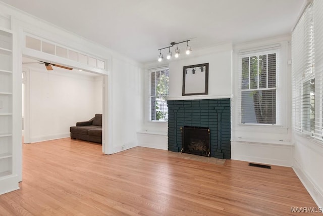 610 Ponce De Leon Ave, Montgomery, AL 36106 - unfurnished living room featuring light wood finished floors, a brick fireplace, ceiling fan, and crown molding