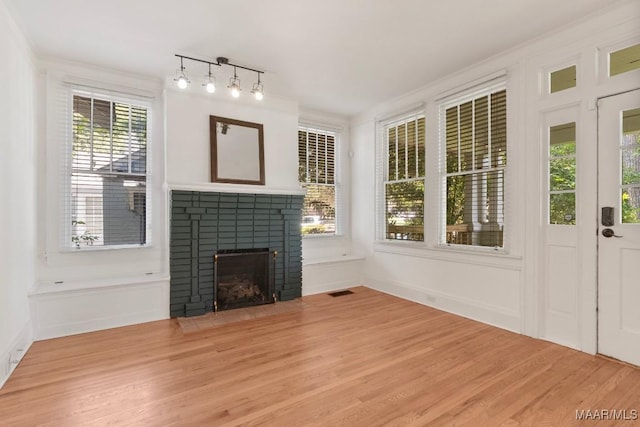 610 Ponce De Leon Ave, Montgomery, AL 36106 - unfurnished living room featuring light wood-style floors, a brick fireplace, and ornamental molding