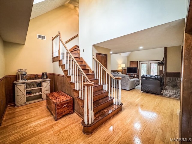 1267 County Road 85th Rd, Prattville, AL 36067 - staircase with hardwood / wood-style floors, wainscoting, a towering ceiling, french doors, and wood walls