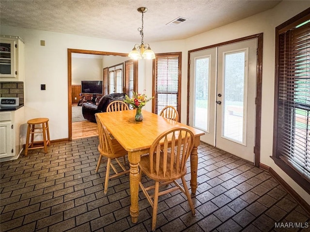 1267 County Road 85th Rd, Prattville, AL 36067 - dining area featuring a chandelier, a textured ceiling, healthy amount of natural light, and french doors