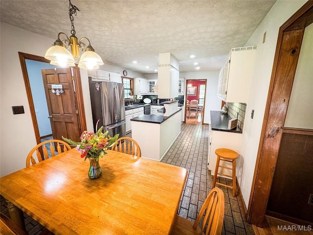 1267 County Road 85th Rd, Prattville, AL 36067 - dining space with a chandelier, brick flooring, a textured ceiling, and recessed lighting