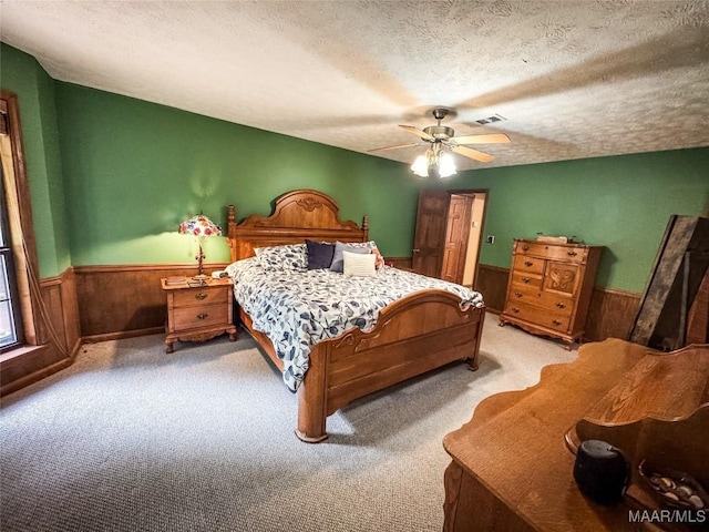 1267 County Road 85th Rd, Prattville, AL 36067 - bedroom featuring wainscoting, light carpet, wooden walls, a textured ceiling, and ceiling fan