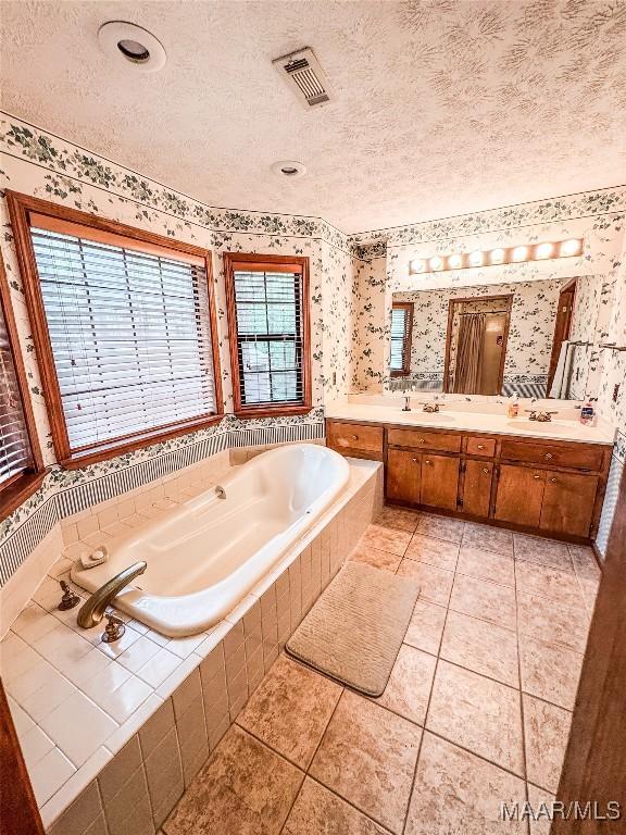 1267 County Road 85th Rd, Prattville, AL 36067 - full bath featuring wallpapered walls, a garden tub, double vanity, a textured ceiling, and tile patterned flooring