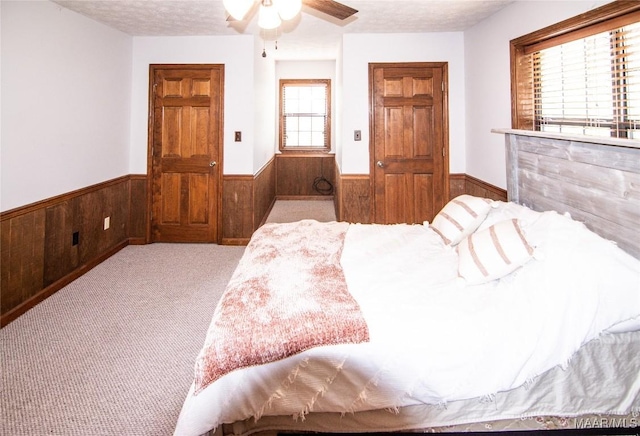 1267 County Road 85th Rd, Prattville, AL 36067 - carpeted bedroom with a wainscoted wall, wood walls, a textured ceiling, and a ceiling fan