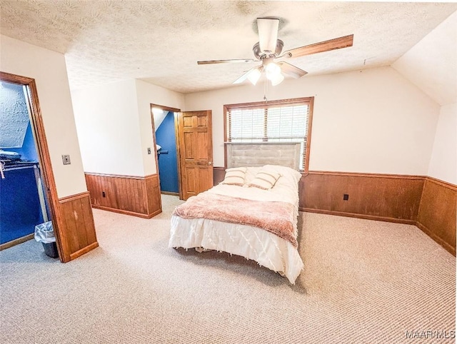 1267 County Road 85th Rd, Prattville, AL 36067 - carpeted bedroom with a wainscoted wall, wood walls, a ceiling fan, lofted ceiling, and a textured ceiling