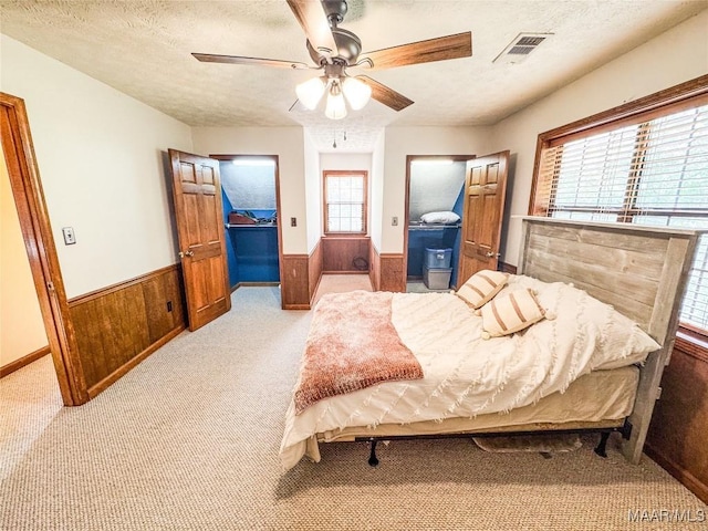 1267 County Road 85th Rd, Prattville, AL 36067 - bedroom with wainscoting, light carpet, a textured ceiling, wooden walls, and a ceiling fan
