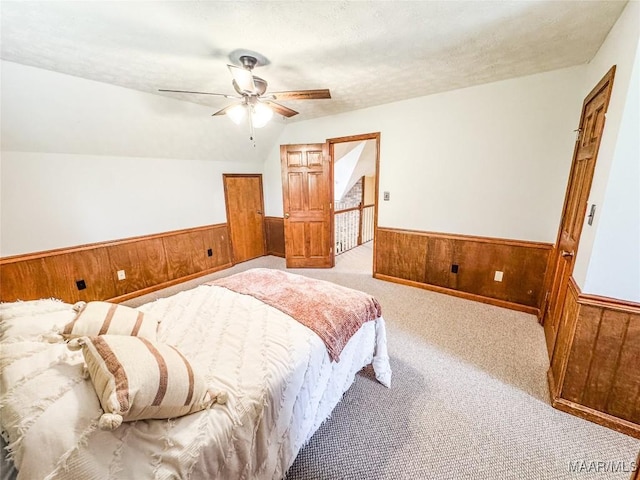 1267 County Road 85th Rd, Prattville, AL 36067 - carpeted bedroom with wainscoting, wooden walls, ceiling fan, and vaulted ceiling