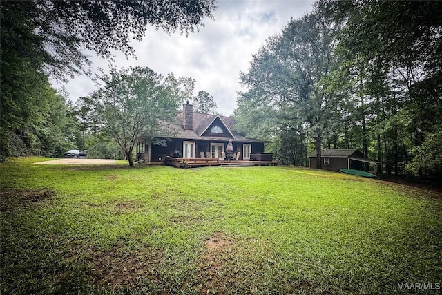 1267 County Road 85th Rd, Prattville, AL 36067 - back of property featuring a wooden deck, a lawn, a chimney, and a storage unit