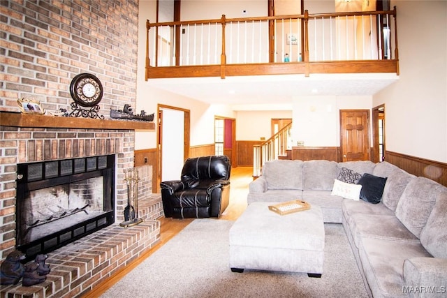 1267 County Road 85th Rd, Prattville, AL 36067 - living room with wainscoting, a high ceiling, a fireplace, stairs, and wooden walls