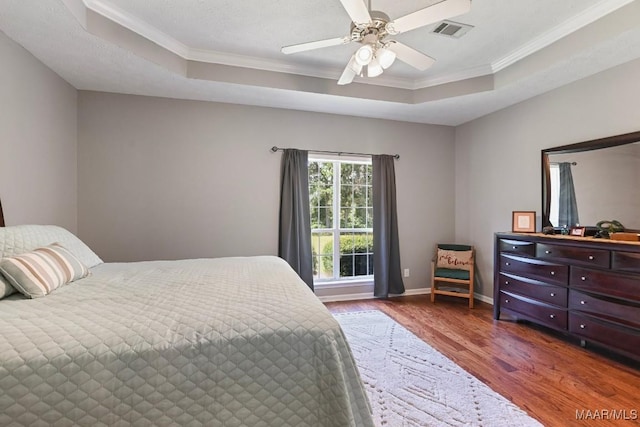 709 Liberty Rd, Tallassee, AL 36078 - bedroom with a tray ceiling, wood finished floors, crown molding, and a ceiling fan