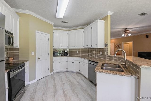709 Liberty Rd, Tallassee, AL 36078 - kitchen featuring appliances with stainless steel finishes, a peninsula, ceiling fan, decorative backsplash, and crown molding