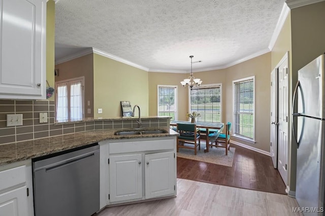 709 Liberty Rd, Tallassee, AL 36078 - kitchen with appliances with stainless steel finishes, a peninsula, a chandelier, white cabinets, and a textured ceiling