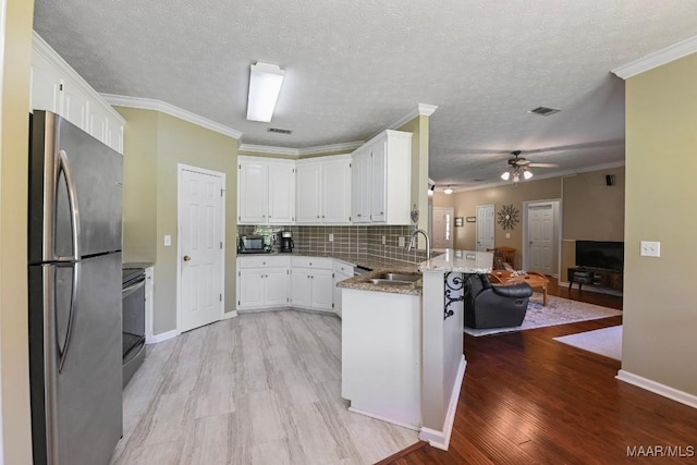709 Liberty Rd, Tallassee, AL 36078 - kitchen with appliances with stainless steel finishes, a peninsula, white cabinets, ceiling fan, and light stone countertops