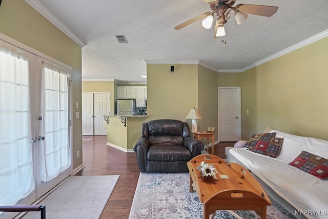 709 Liberty Rd, Tallassee, AL 36078 - living area featuring dark wood-type flooring, ceiling fan, a textured ceiling, and crown molding