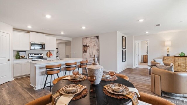 6036 Cunningham Trl, Montgomery, AL 36116 - kitchen with stainless steel appliances, wood finished floors, an island with sink, open floor plan, and recessed lighting