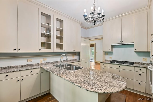 1327 Woodward Ave, Montgomery, AL 36106 - kitchen with stainless steel gas stovetop, a chandelier, dark wood finished floors, a peninsula, and ornamental molding