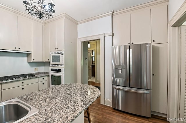 1327 Woodward Ave, Montgomery, AL 36106 - kitchen with appliances with stainless steel finishes, a chandelier, dark wood-style flooring, a kitchen bar, and stone countertops