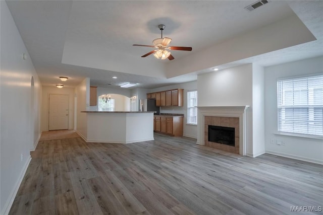 9621 Colleton Pl, Montgomery, AL 36117 - unfurnished living room with light wood-style flooring, ceiling fan, a raised ceiling, a fireplace, and recessed lighting