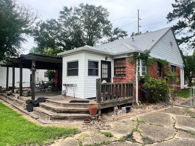 2274 Carter Hill Rd, Montgomery, AL 36106 - rear view of property featuring a metal roof, brick siding, and a deck