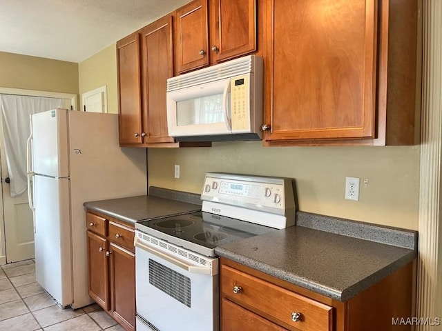 2274 Carter Hill Rd, Montgomery, AL 36106 - kitchen featuring white appliances, dark countertops, brown cabinets, and light tile patterned floors