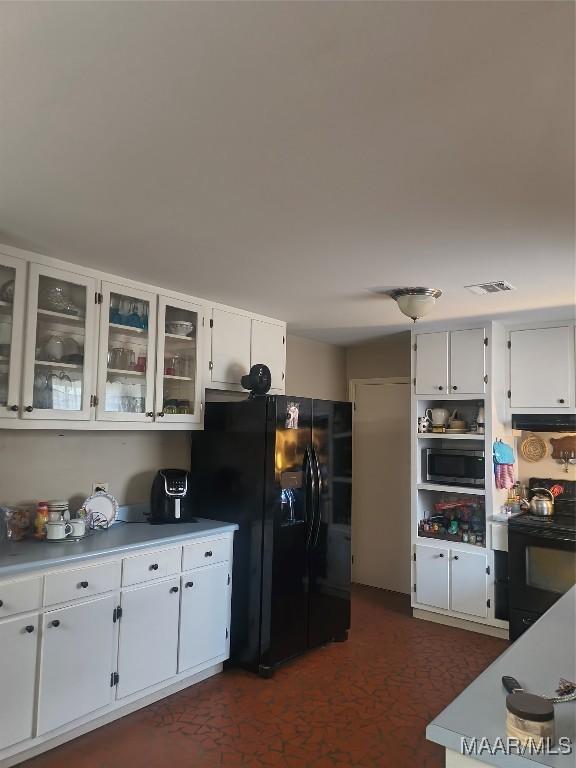 2205 Old Orrville Rd, Selma, AL 36701 - kitchen with black appliances, white cabinetry, glass insert cabinets, and light countertops