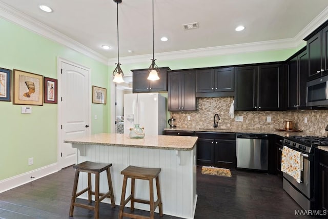 301 Eastgate Dr, Prattville, AL 36066 - kitchen featuring appliances with stainless steel finishes, a kitchen breakfast bar, decorative backsplash, a kitchen island, and dark wood-style floors