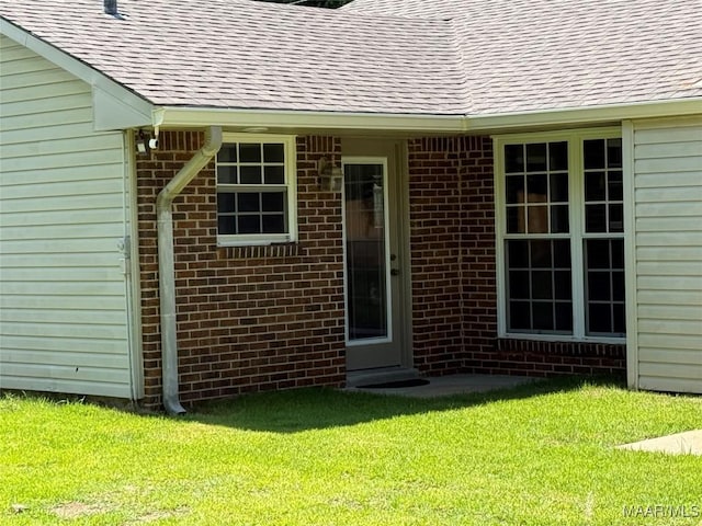 311 Old Marion Junction Rd, Selma, AL 36701 - property entrance featuring a shingled roof, a yard, and brick siding