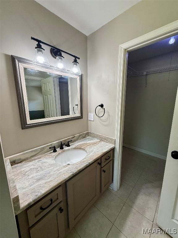 311 Old Marion Junction Rd, Selma, AL 36701 - bathroom with vanity, a spacious closet, and tile patterned floors