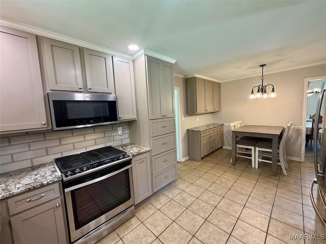 311 Old Marion Junction Rd, Selma, AL 36701 - kitchen with appliances with stainless steel finishes, decorative backsplash, light tile patterned floors, a chandelier, and pendant lighting