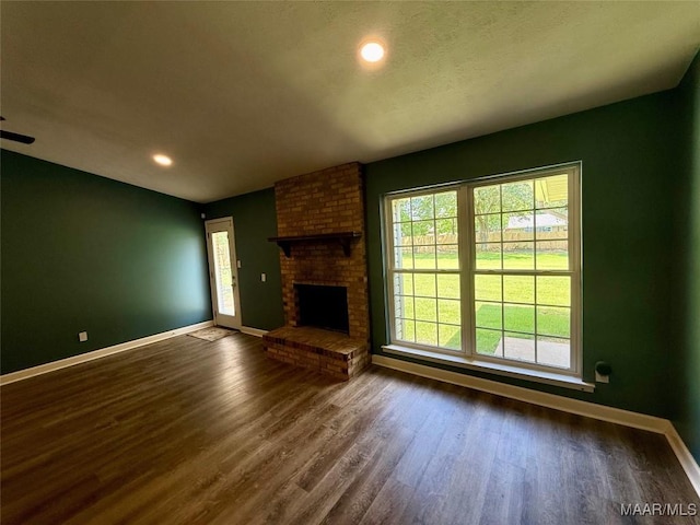 311 Old Marion Junction Rd, Selma, AL 36701 - unfurnished living room with dark wood-type flooring, a fireplace, and recessed lighting