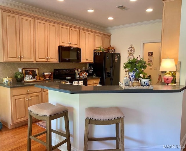5650 Ash Grove Ct, Montgomery, AL 36116 - kitchen with black appliances, dark countertops, a breakfast bar area, decorative backsplash, and ornamental molding
