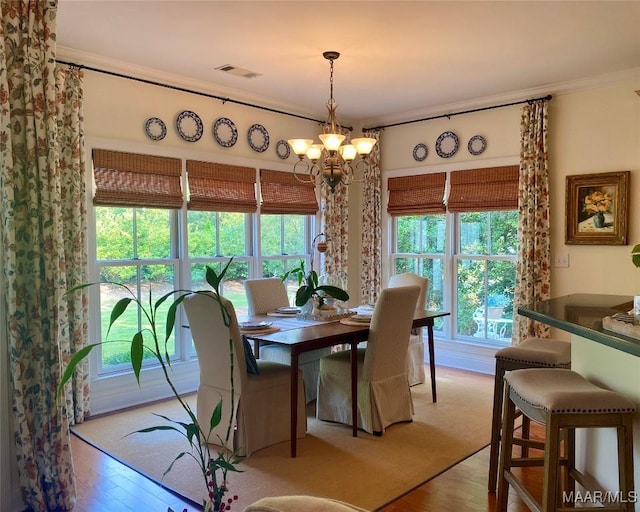 5650 Ash Grove Ct, Montgomery, AL 36116 - dining space with light wood finished floors, ornamental molding, and a chandelier