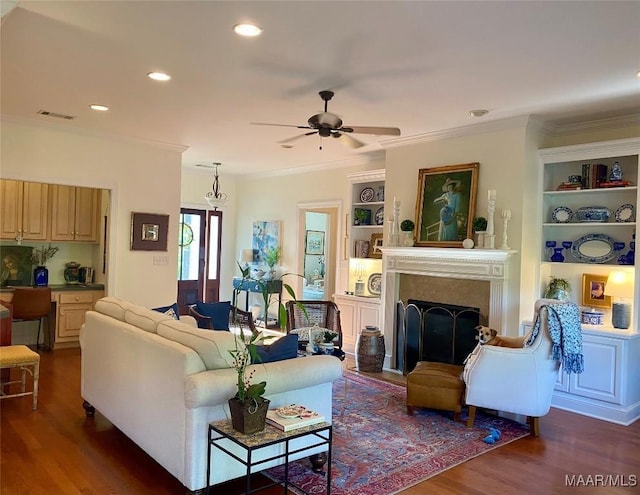 5650 Ash Grove Ct, Montgomery, AL 36116 - living area with dark wood finished floors, ceiling fan, crown molding, built in shelves, and a fireplace