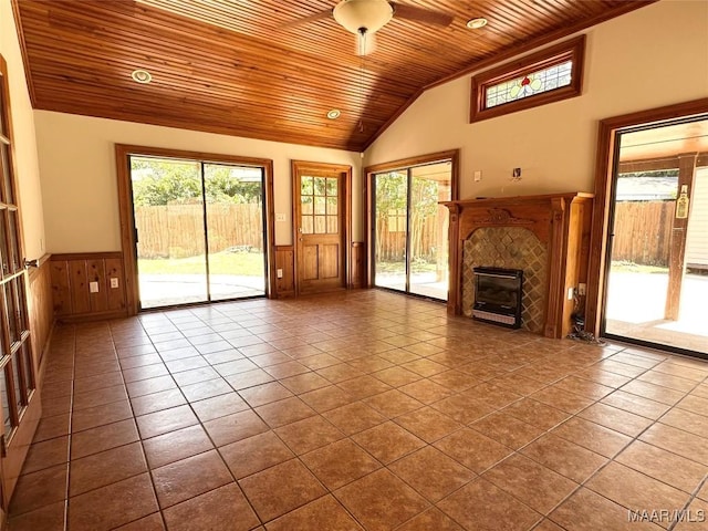3551 Dalraida Pkwy, Montgomery, AL 36109 - unfurnished living room featuring wood ceiling, a wainscoted wall, a tile fireplace, dark tile patterned floors, and plenty of natural light