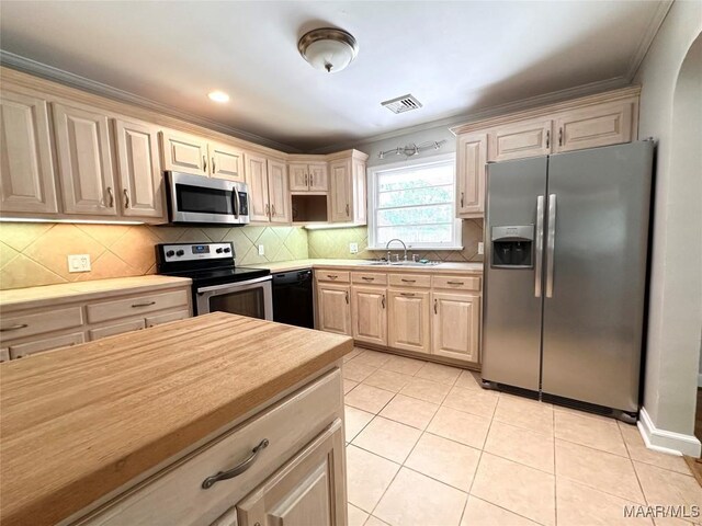 3551 Dalraida Pkwy, Montgomery, AL 36109 - kitchen featuring stainless steel appliances, crown molding, light countertops, backsplash, and light tile patterned floors