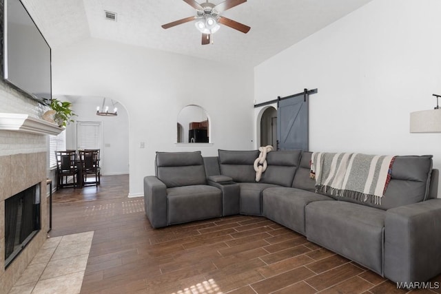 6526 Ridgeview Ln, Montgomery, AL 36116 - living room with a barn door, wood finished floors, ceiling fan, a tile fireplace, and a chandelier