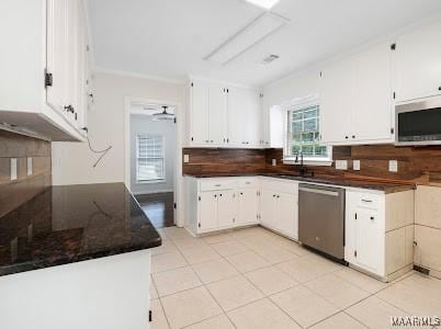 1243 Highpoint Rd, Montgomery, AL 36109 - kitchen with stainless steel appliances, white cabinets, and backsplash