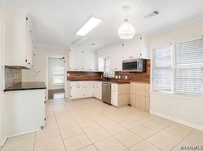 1243 Highpoint Rd, Montgomery, AL 36109 - kitchen with stainless steel appliances, decorative backsplash, healthy amount of natural light, and light tile patterned floors