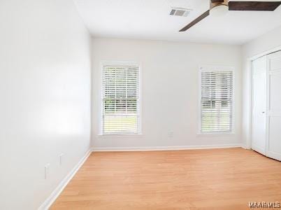 1243 Highpoint Rd, Montgomery, AL 36109 - unfurnished bedroom featuring light wood finished floors, multiple windows, a closet, and ceiling fan