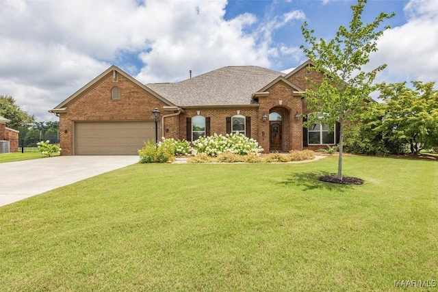 9185 Brenham Ct, Montgomery, AL 36117 - view of front facade with brick siding, driveway, a garage, a front yard, and a shingled roof