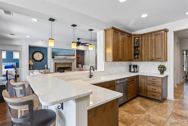 9185 Brenham Ct, Montgomery, AL 36117 - kitchen featuring dishwasher, a peninsula, brown cabinets, a breakfast bar area, and open floor plan