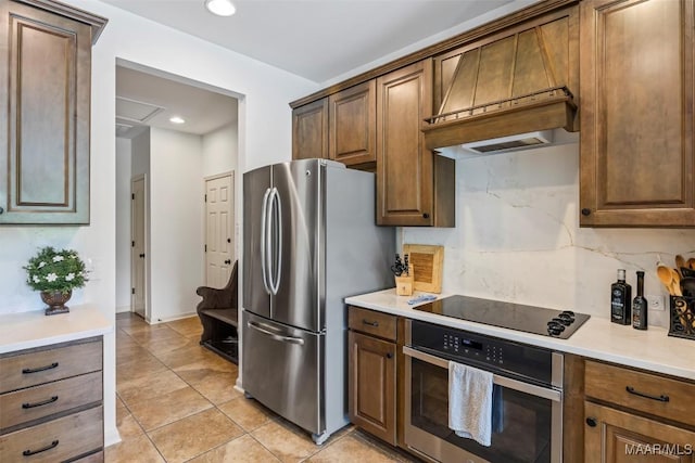 9185 Brenham Ct, Montgomery, AL 36117 - kitchen with appliances with stainless steel finishes, premium range hood, light tile patterned floors, light countertops, and recessed lighting