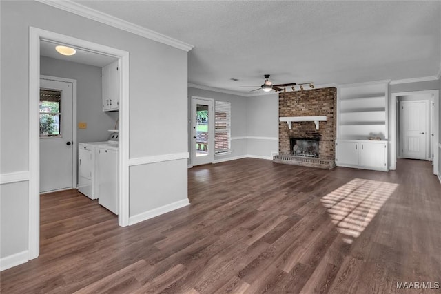 3213 Milan Dr, Montgomery, AL 36109 - unfurnished living room featuring a ceiling fan, separate washer and dryer, ornamental molding, dark wood-style flooring, and a fireplace