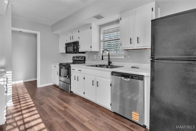 3213 Milan Dr, Montgomery, AL 36109 - kitchen featuring black appliances, light countertops, dark wood finished floors, and white cabinetry