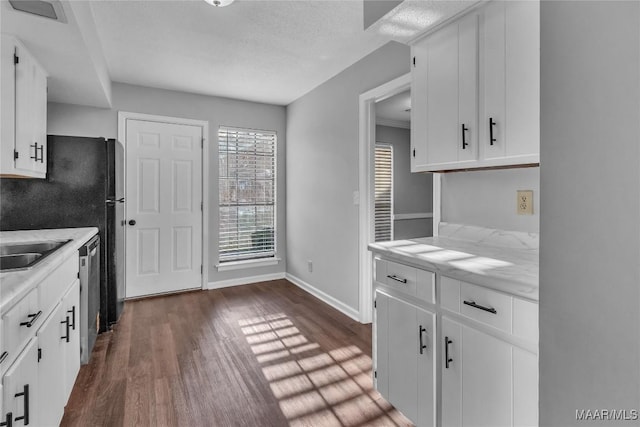 3213 Milan Dr, Montgomery, AL 36109 - kitchen with dark wood-style floors, light countertops, white cabinets, a textured ceiling, and dishwasher