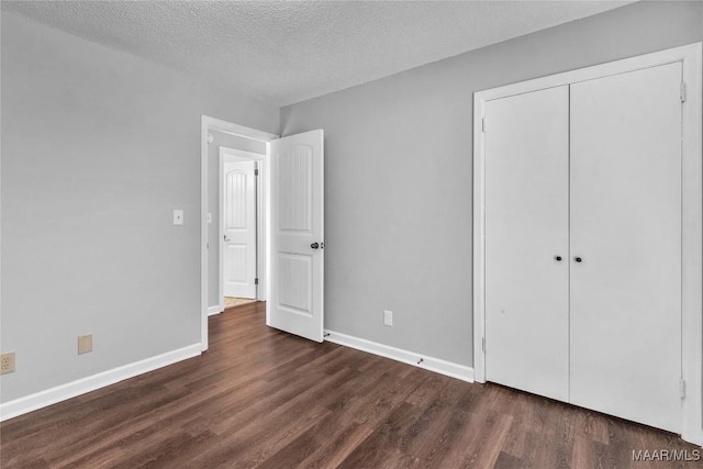 3213 Milan Dr, Montgomery, AL 36109 - unfurnished bedroom with dark wood-style flooring, a textured ceiling, and a closet