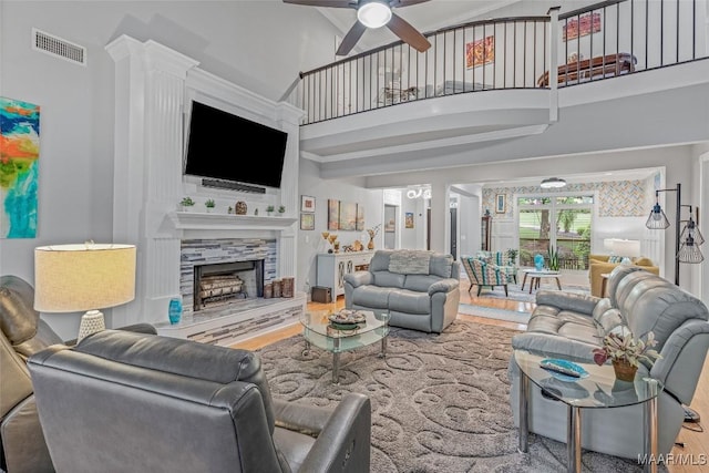 378 Winding Wood Dr, Wetumpka, AL 36093 - living area with a ceiling fan, wood finished floors, a high ceiling, and a fireplace with raised hearth