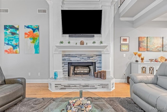 378 Winding Wood Dr, Wetumpka, AL 36093 - living area featuring wood finished floors, a fireplace with raised hearth, and crown molding