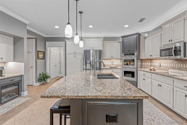 378 Winding Wood Dr, Wetumpka, AL 36093 - kitchen with stainless steel appliances, crown molding, backsplash, a breakfast bar, and a center island with sink
